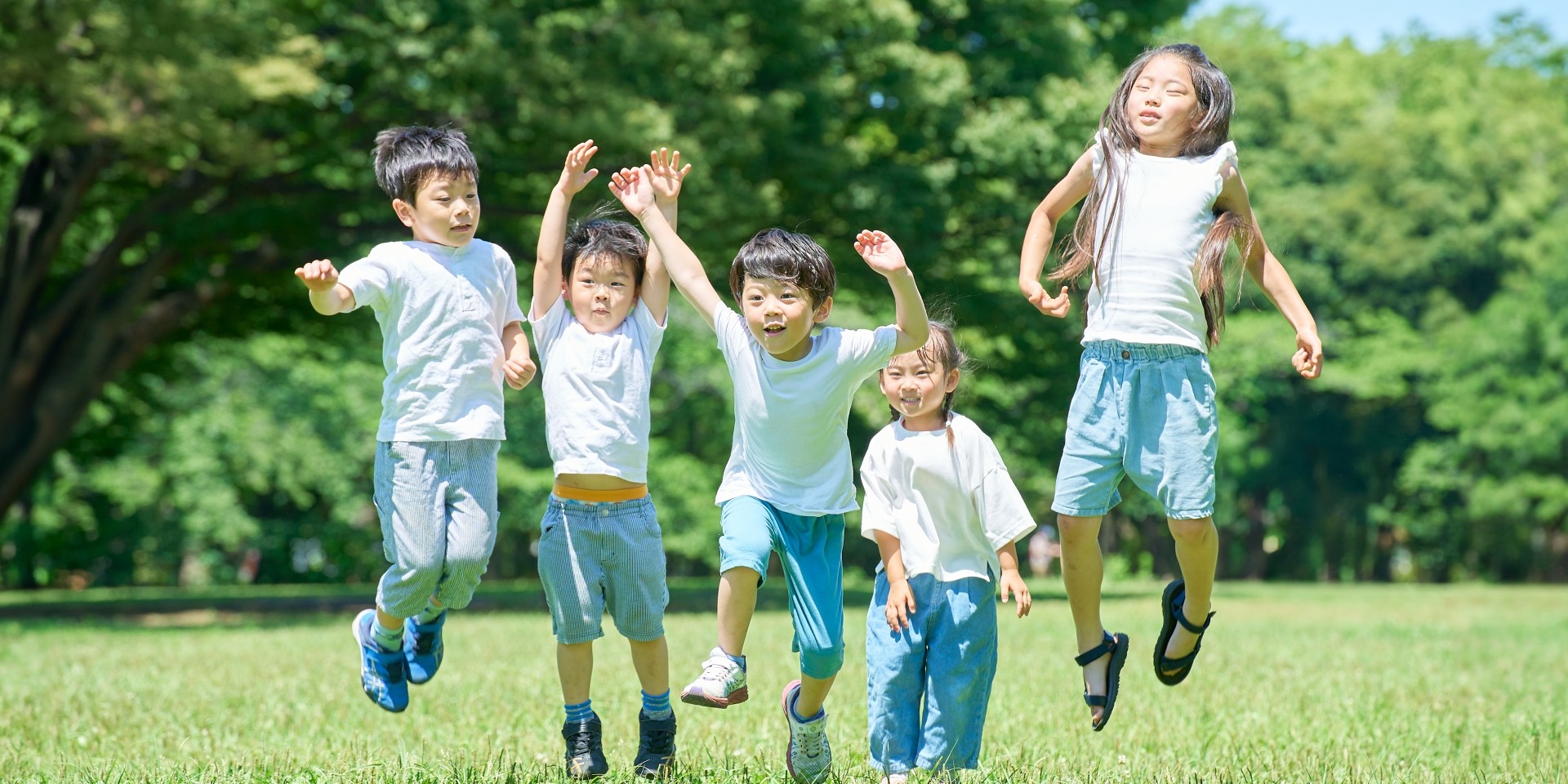 子どもたちが緑の中で走っている様子